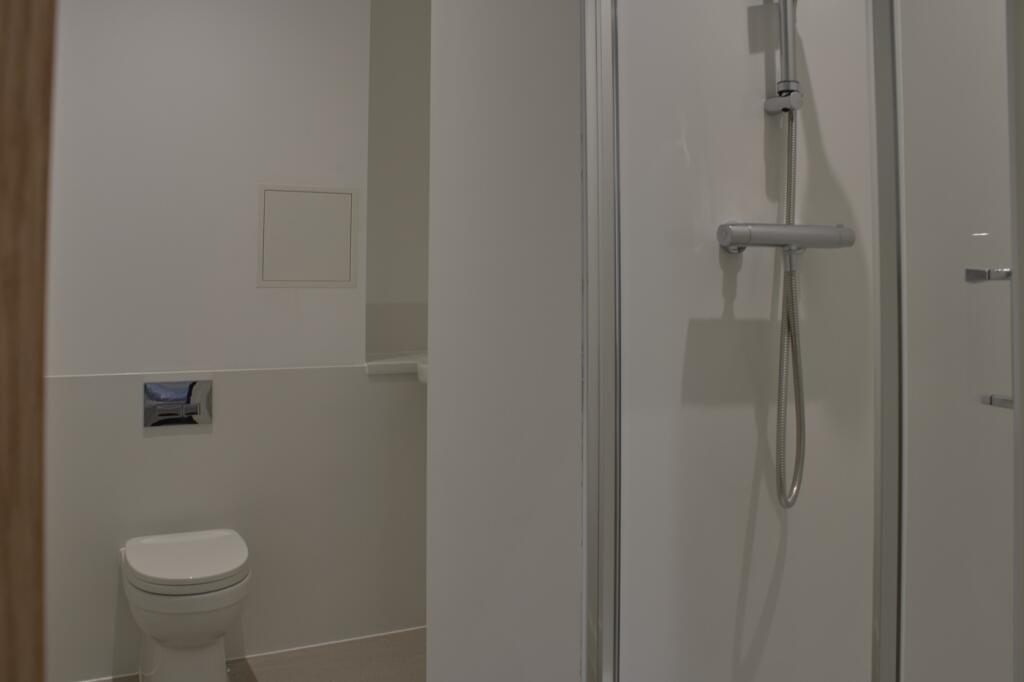 A modern and tidy bathroom featuring a spacious...