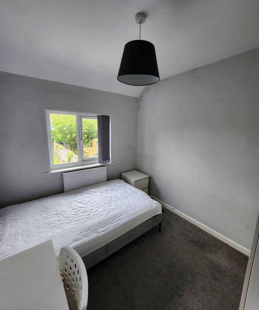 A clean and bright double bedroom featuring a w...