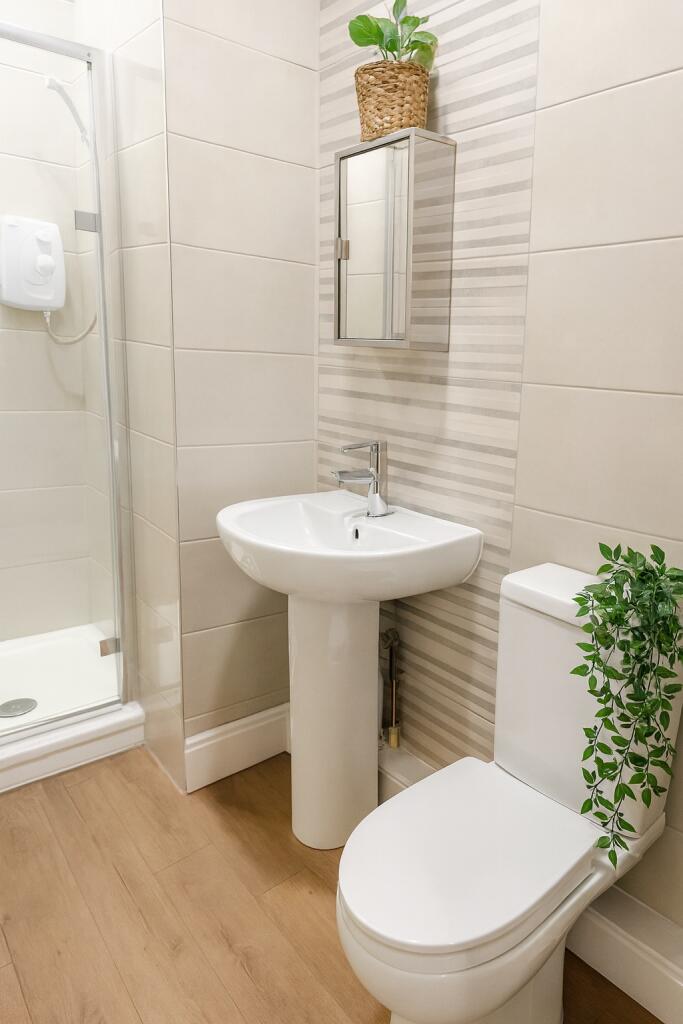 A clean and modern bathroom featuring a walk-in...