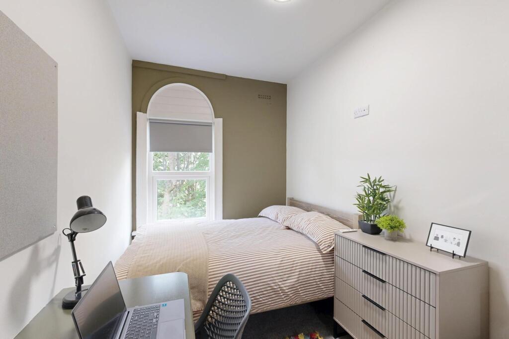 A bright and welcoming double bedroom featuring...