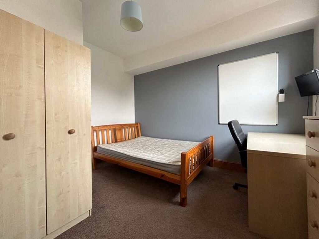 A tidy and well-furnished double bedroom with a...
