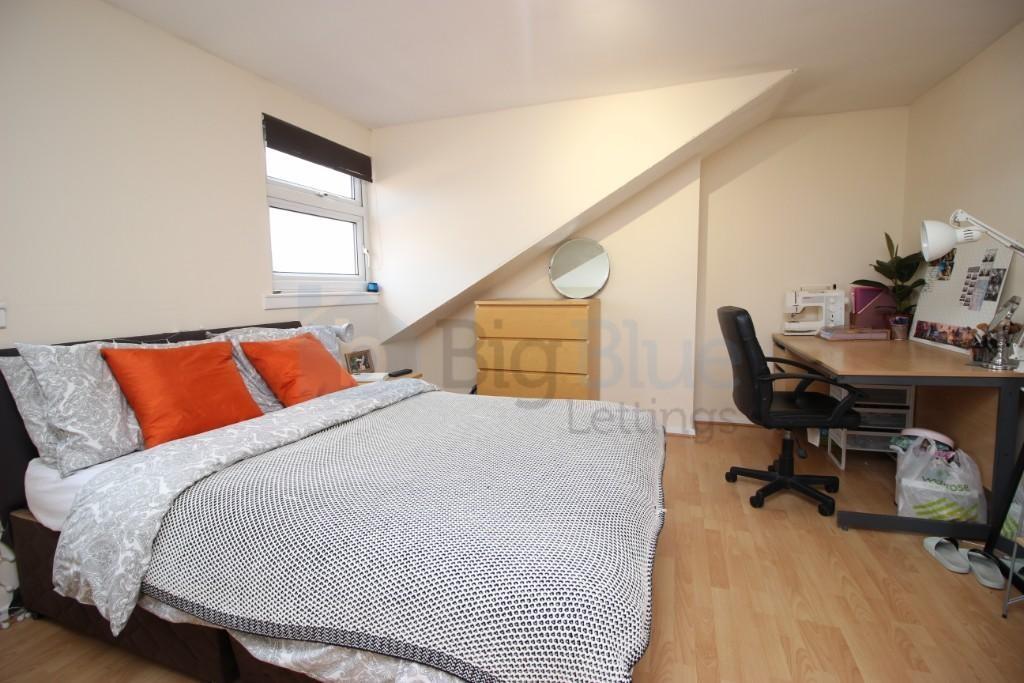 Bright double bedroom featuring a comfortable b...