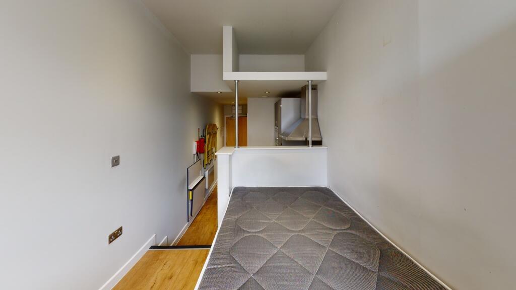 A neat and simple single bedroom featuring a wo...