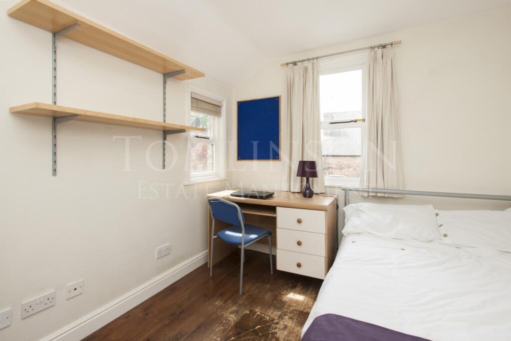 A bright and tidy double bedroom featuring a de...