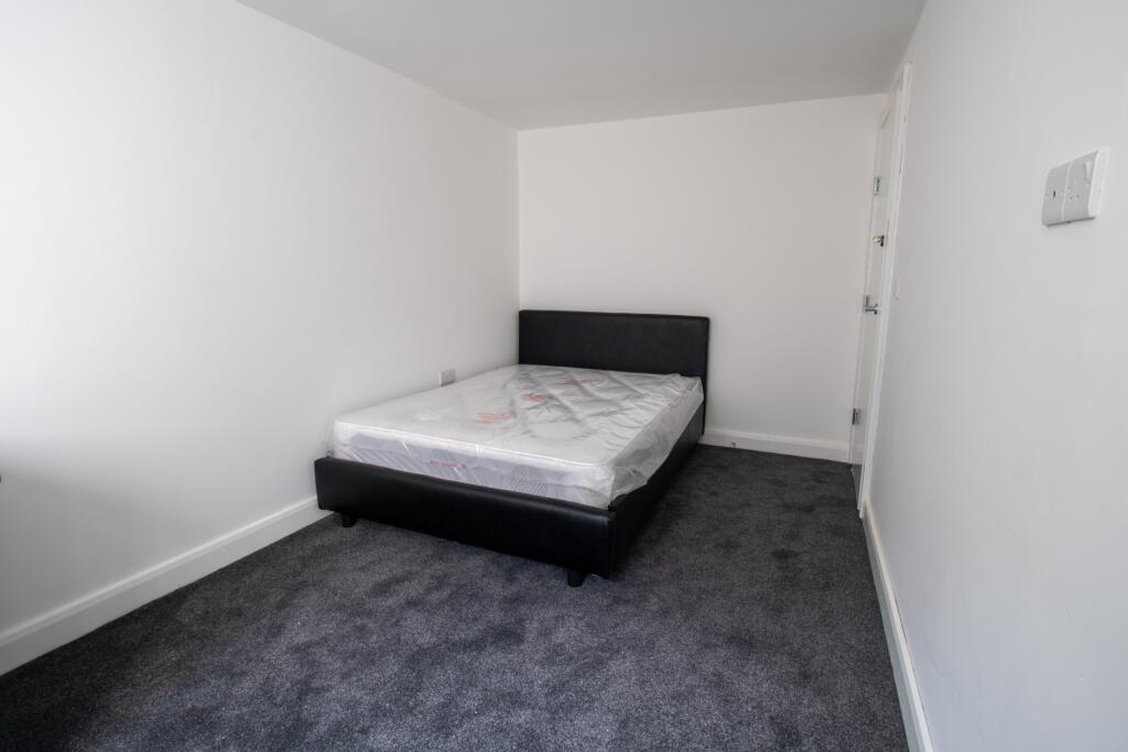A tidy and simple bedroom featuring a double be...