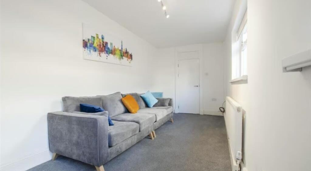 A neat and modern living room featuring a comfo...