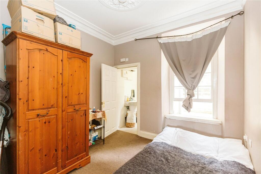 A cozy single bedroom featuring a large wooden ...