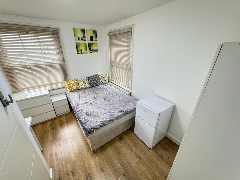 Bright double bedroom featuring large windows w...