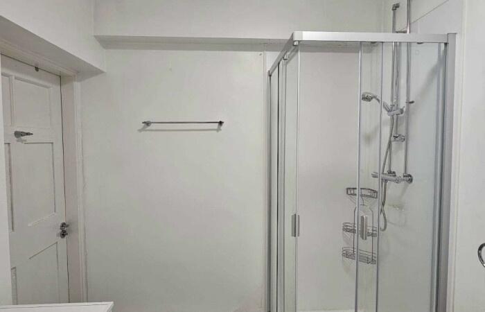 A clean and modern bathroom featuring a glass-e...