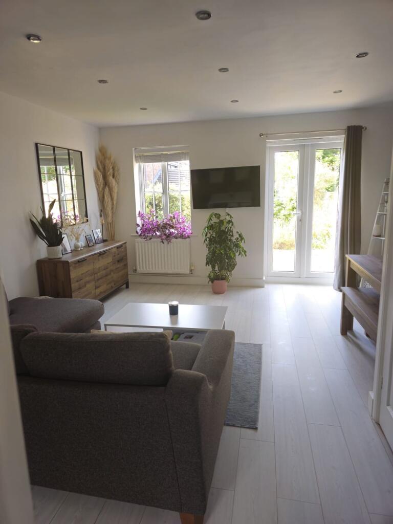 A bright and welcoming living room featuring mo...