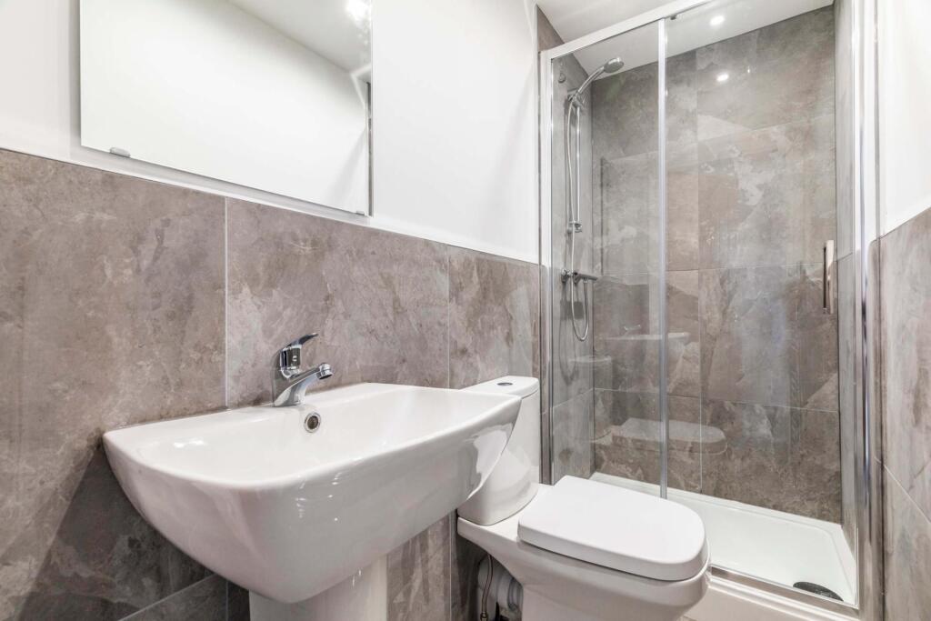 Modern bathroom with a walk-in glass shower, wh...
