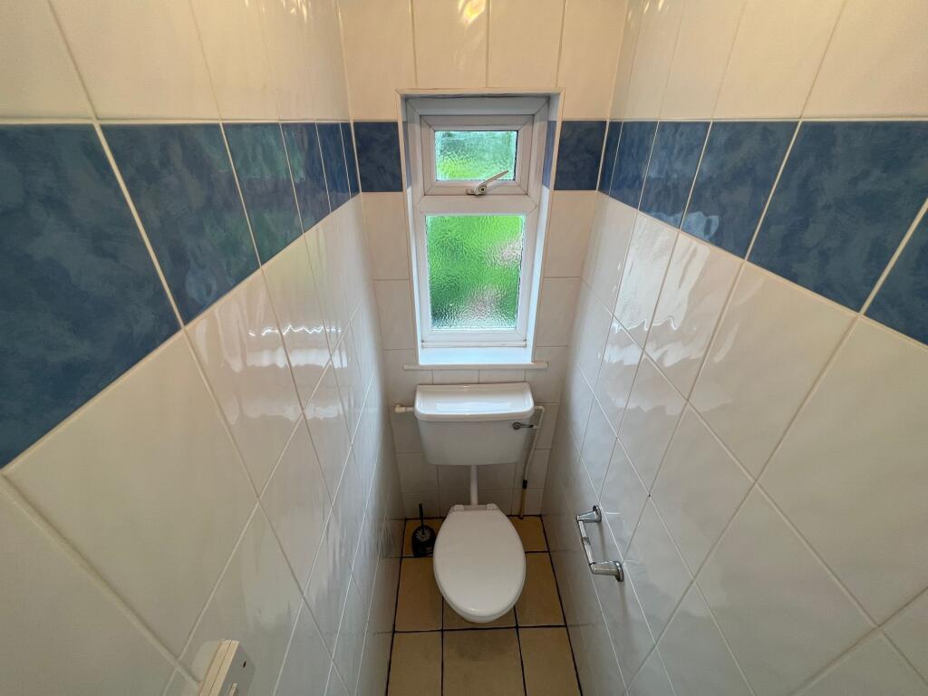 Bright and clean single toilet room featuring w...
