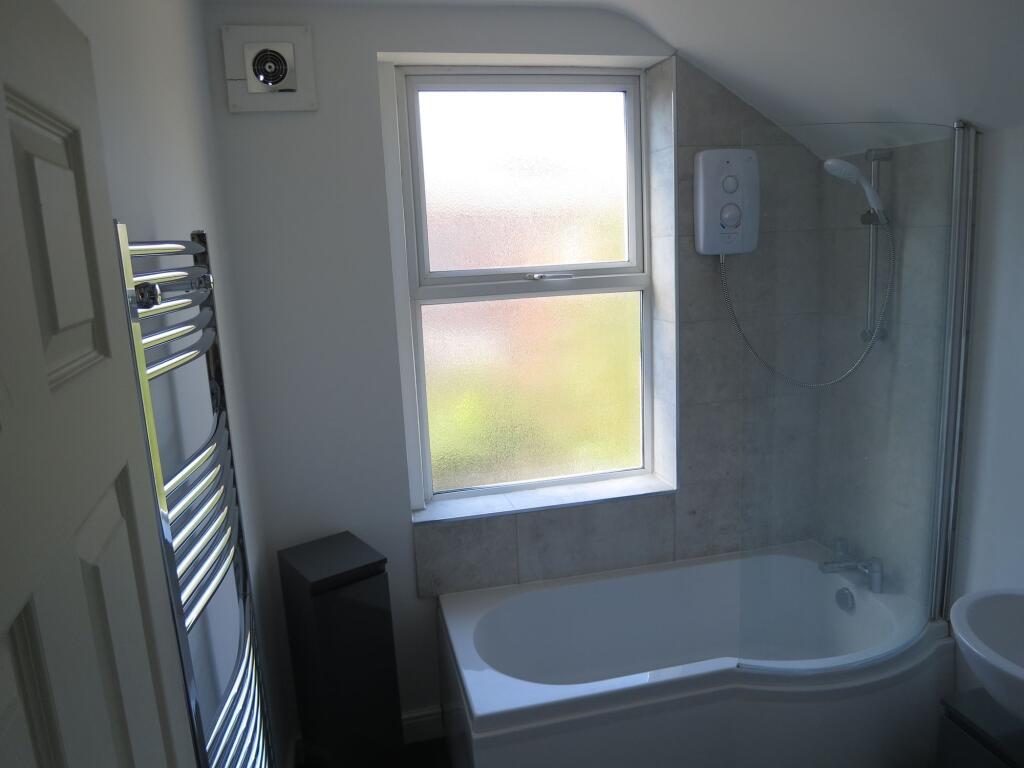 Bright and clean bathroom suite featuring a mod...