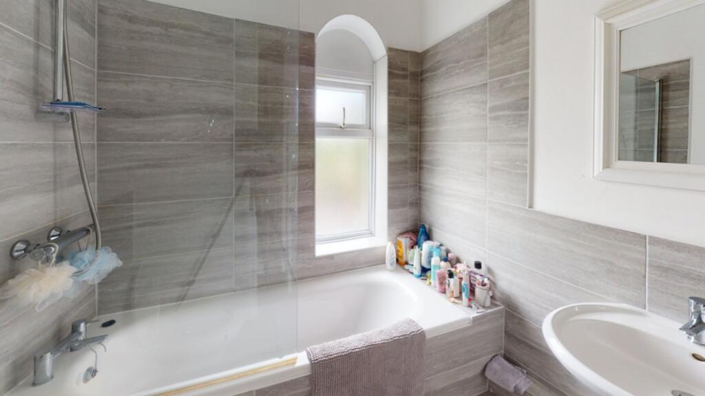 A modern and spacious bathroom featuring a rela...