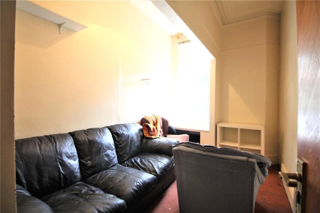 A cozy living room featuring a black leather so...