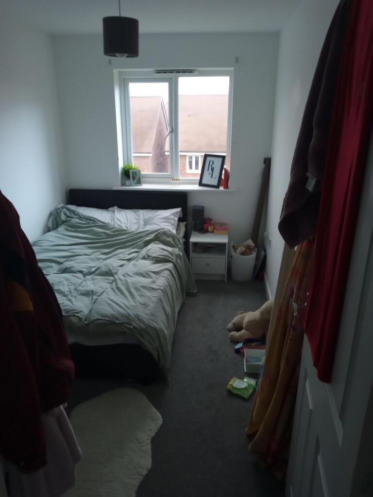 Bright, simply furnished bedroom with a double ...