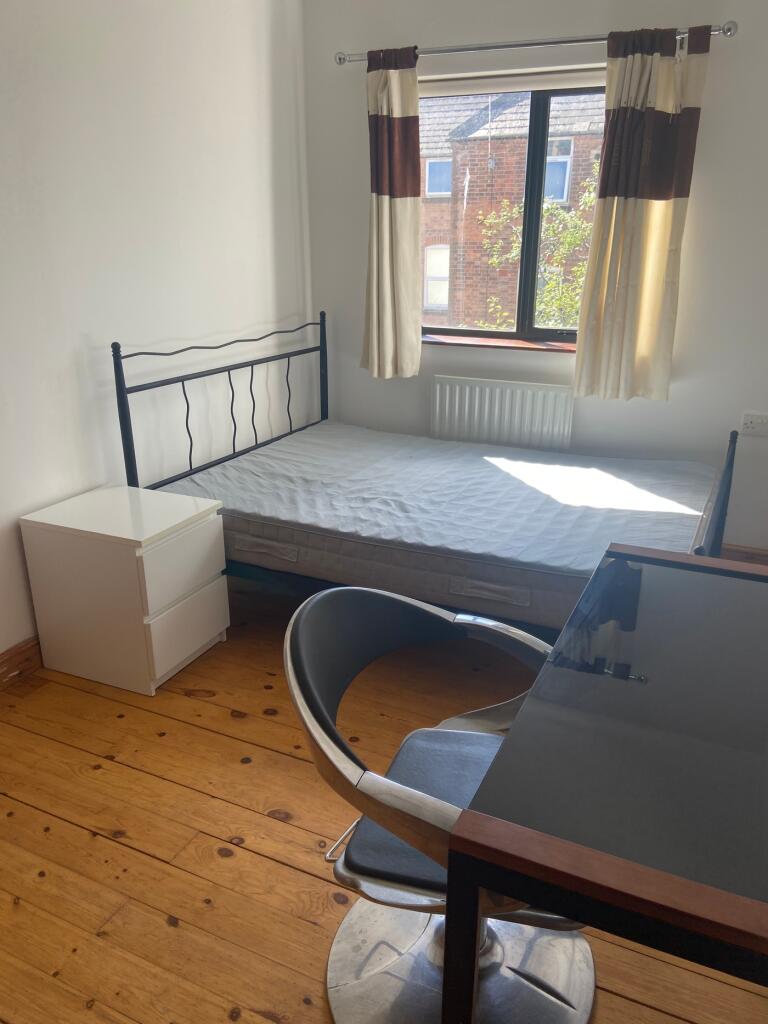 A bright and tidy double bedroom featuring a co...