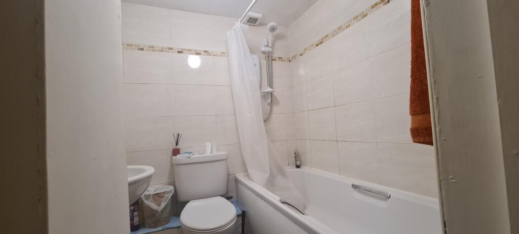 A functional bathroom featuring a bathtub with ...
