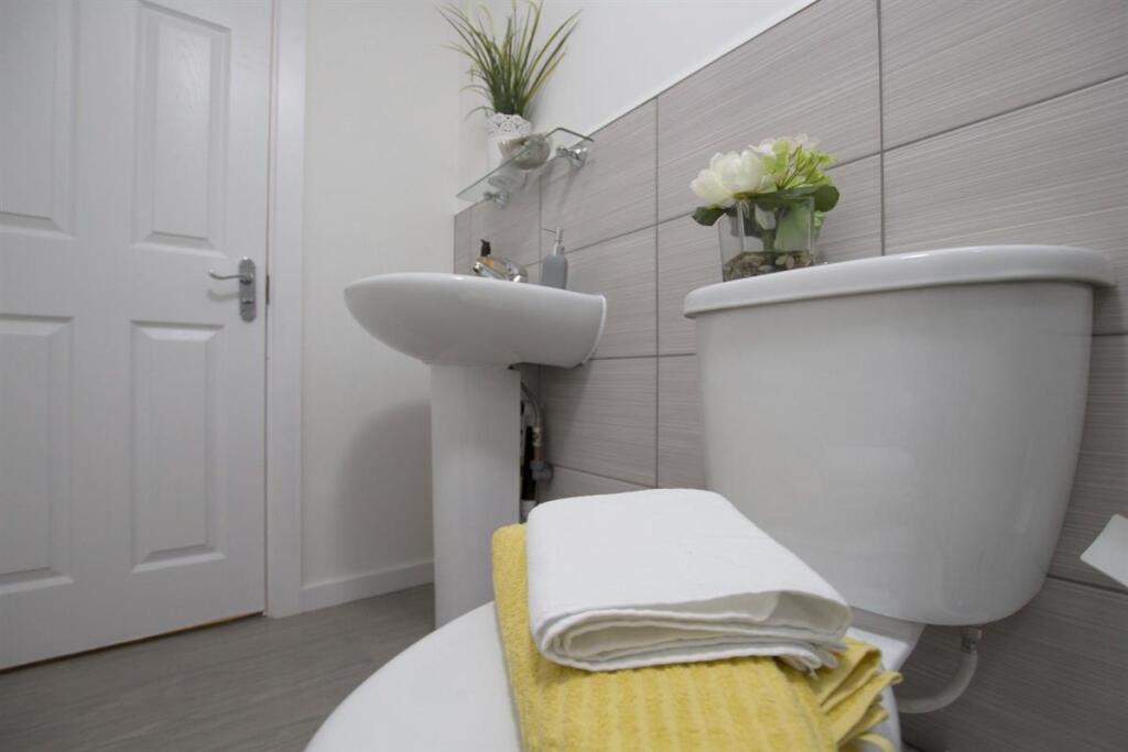 A modern, clean bathroom featuring a white toil...