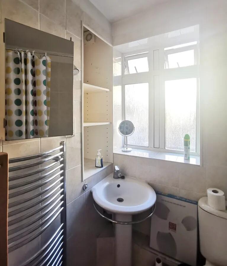 Bright and tidy bathroom featuring a pedestal s...
