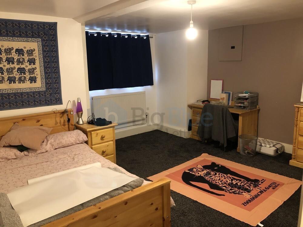 A cozy double bedroom featuring wooden furnitur...