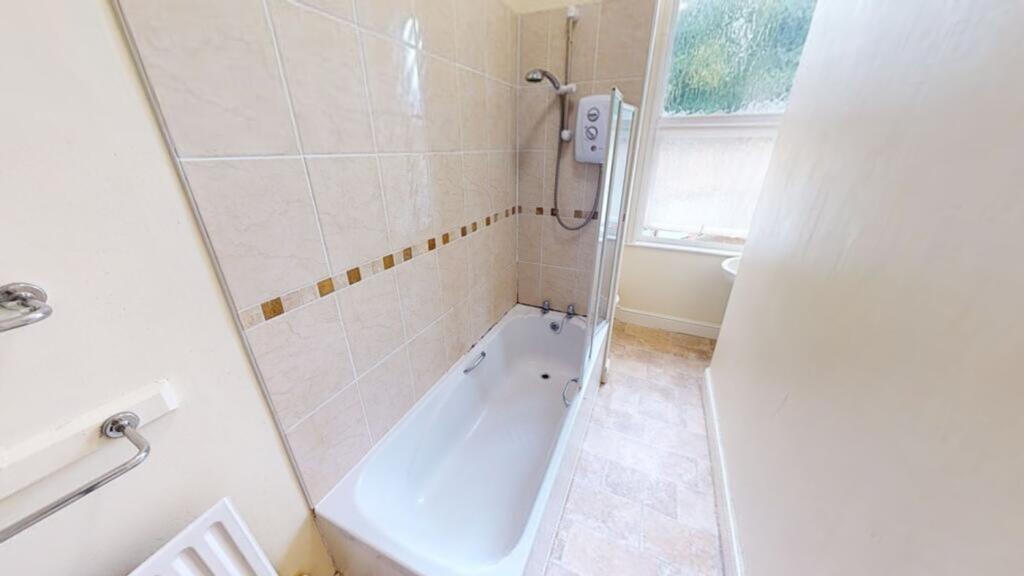 A clean and bright bathroom featuring a shower ...