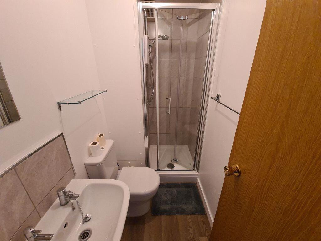 A modern bathroom featuring a compact shower cu...