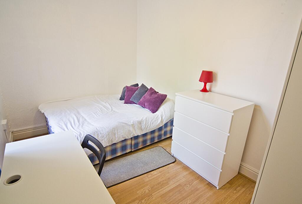 A bright and tidy double bedroom featuring a co...