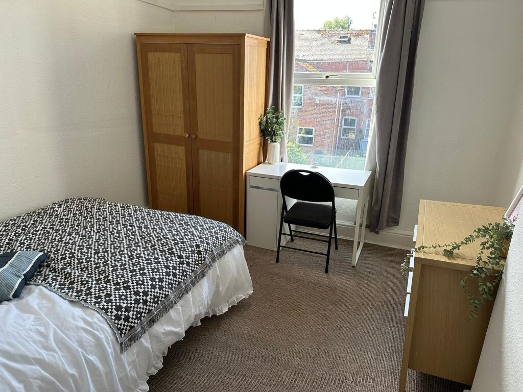 A bright and tidy single bedroom featuring a ne...