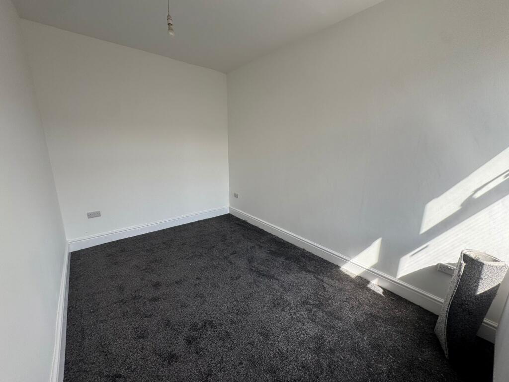 A clean and bright single bedroom with a dark c...