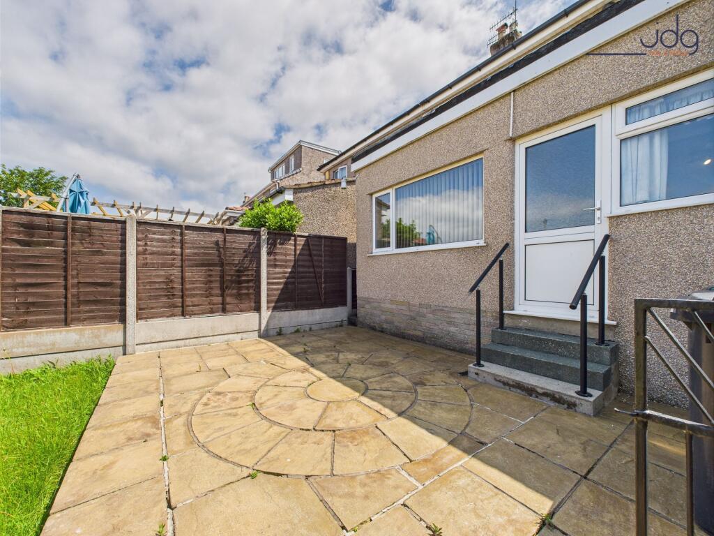 Generously sized garden with a patio and lawn