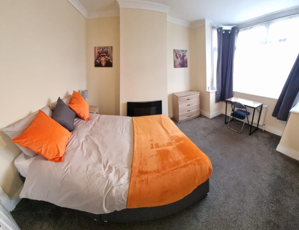 A stylish double bedroom featuring a cozy orang...