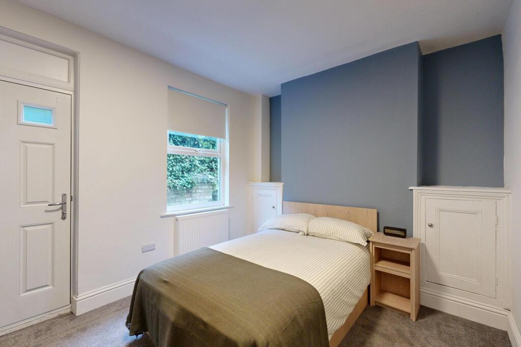 A bright and welcoming bedroom featuring a doub...