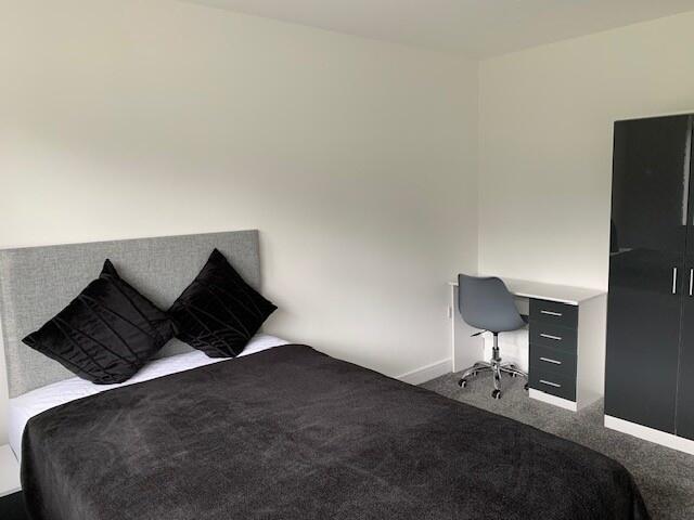 A modern and tidy double bedroom featuring a co...