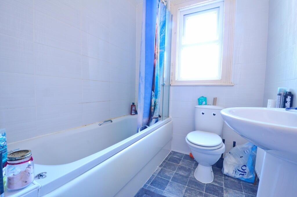A bright, clean bathroom featuring a full batht...
