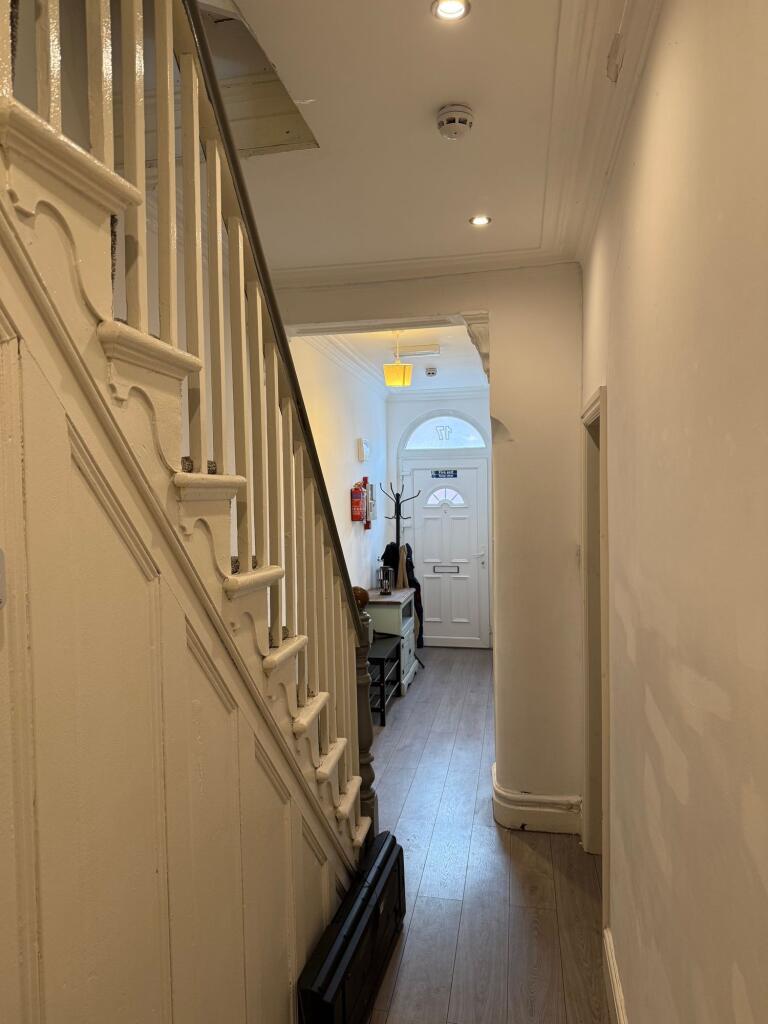 Bright and tidy hallway featuring wooden floori...