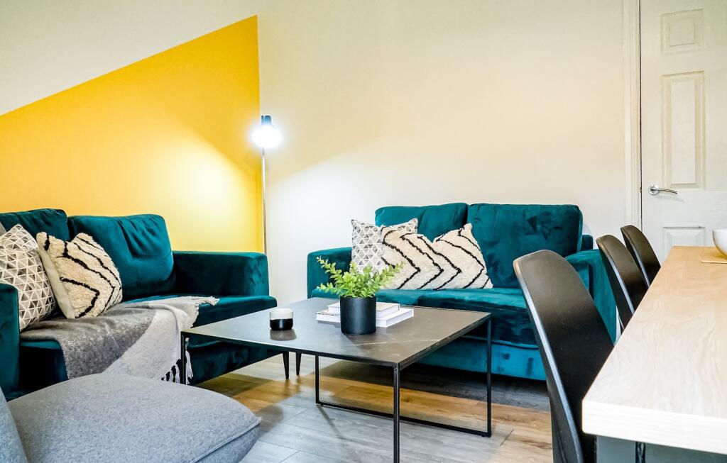 A spacious, modern living room featuring comfor...