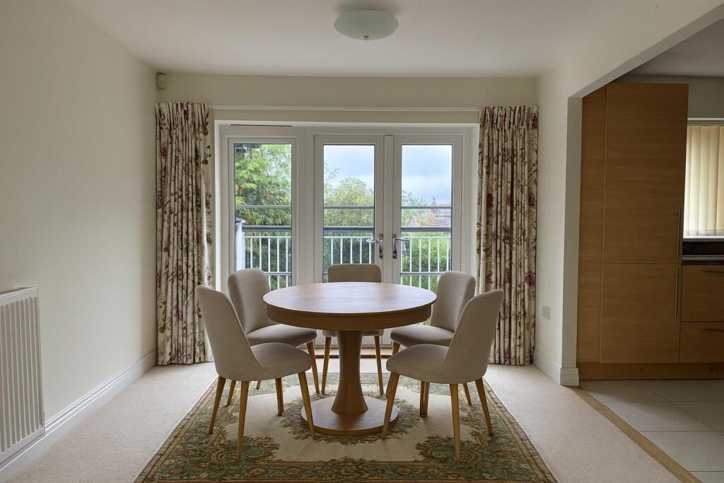 AI staged dining area next to kitchen + actual cur