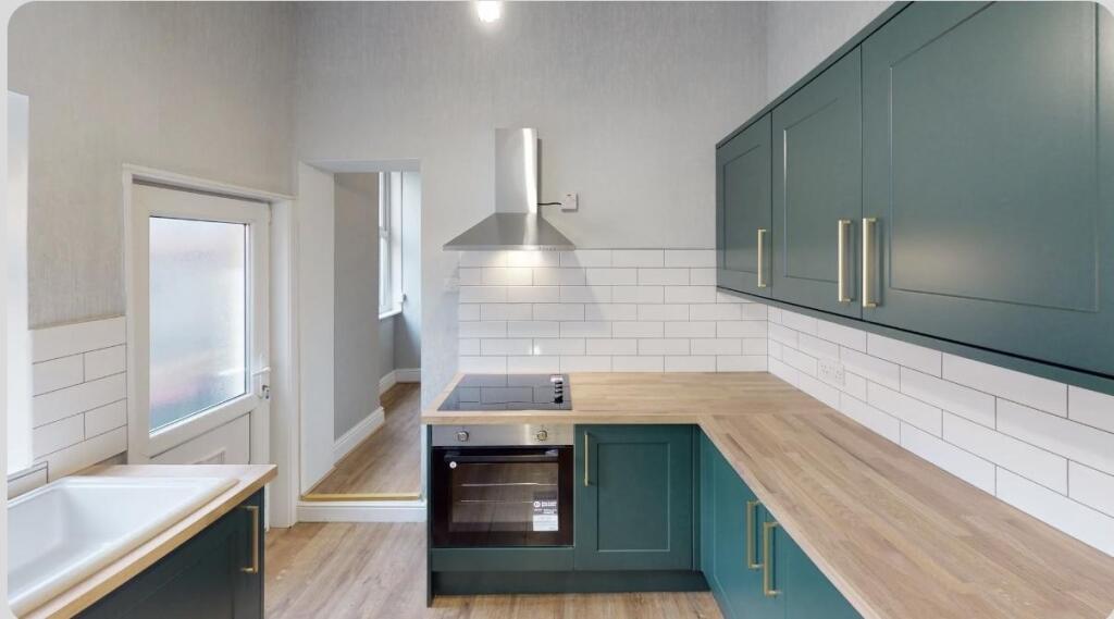 Bright and modern kitchen featuring stylish gre...