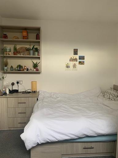 A cozy bedroom featuring a neatly made bed, min...