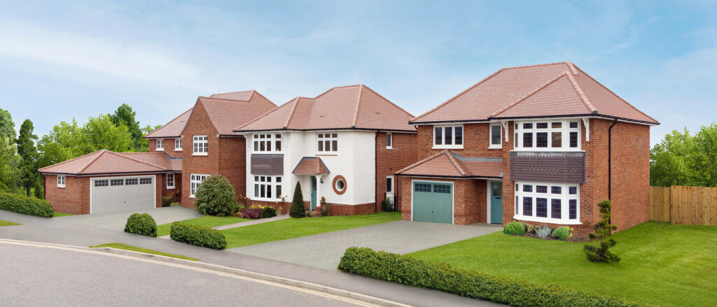 Modern detached houses with brick and white exteriors, bay windows, and well-maintained gardens in a
