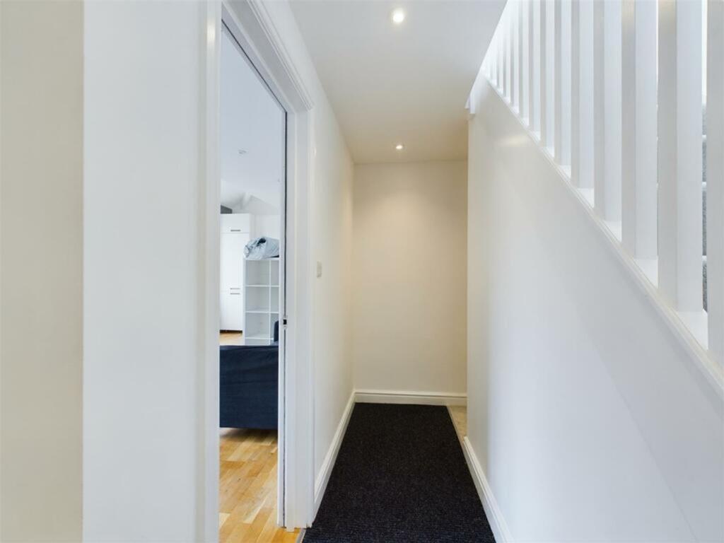A bright and tidy hallway leading to inviting l...