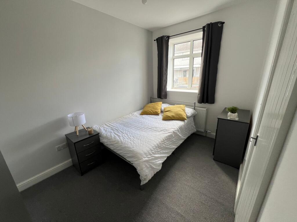 A cozy double bedroom featuring a neatly made b...