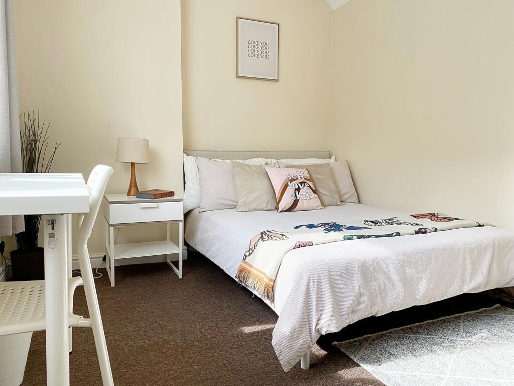 A bright and cozy double bedroom featuring a co...