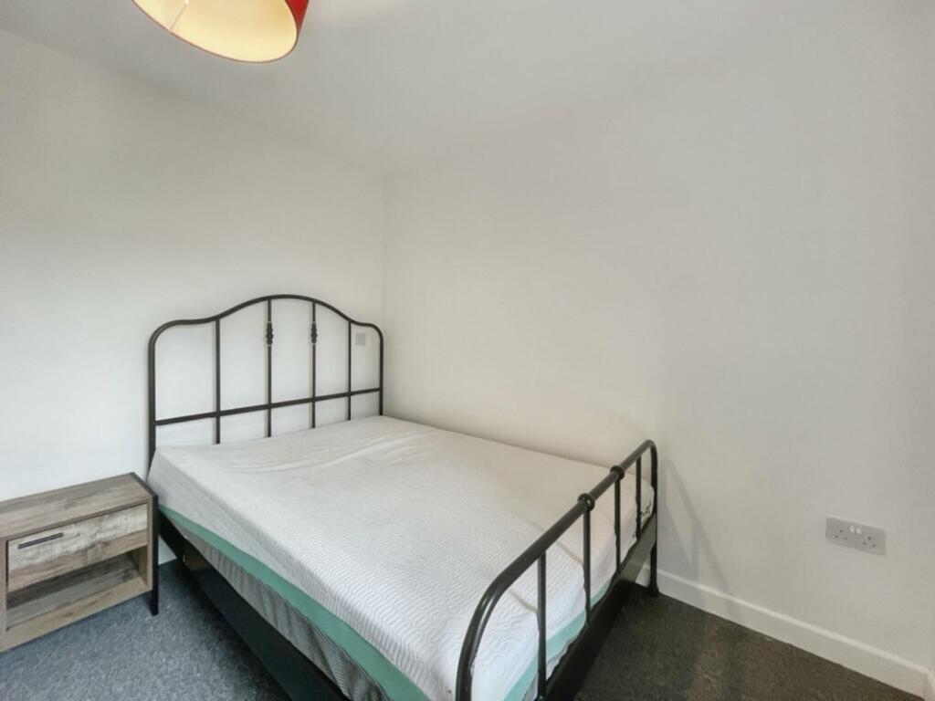 A spacious and tidy double bedroom featuring a ...
