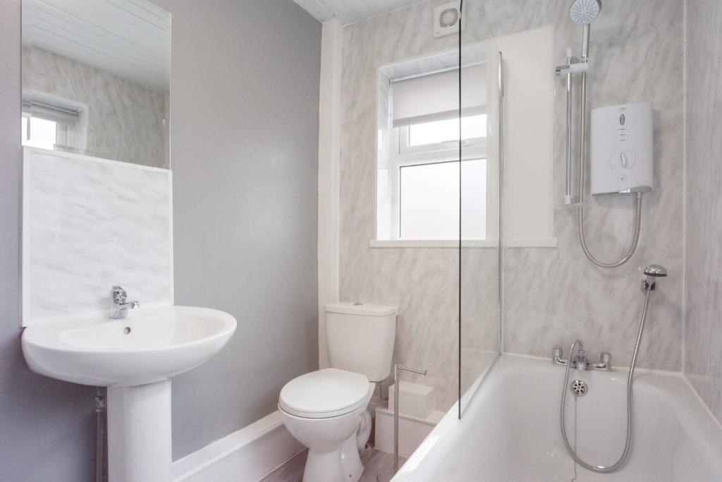 Bright and clean bathroom suite featuring a mod...
