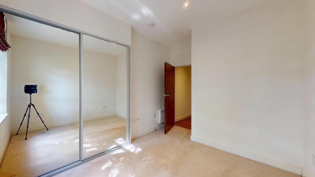 A bright and clean bedroom featuring a large mi...