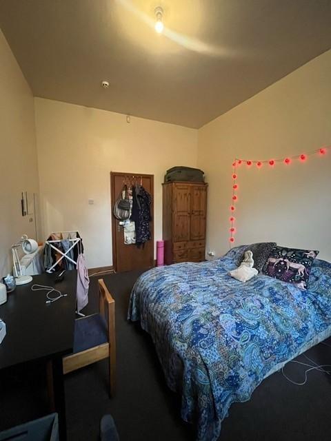 A cozy double bedroom featuring a large bed wit...