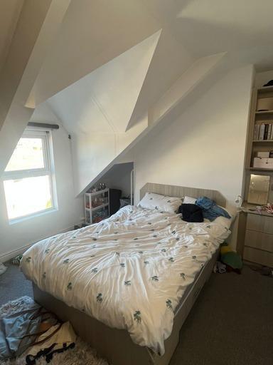 Bright and spacious master bedroom with a comfo...