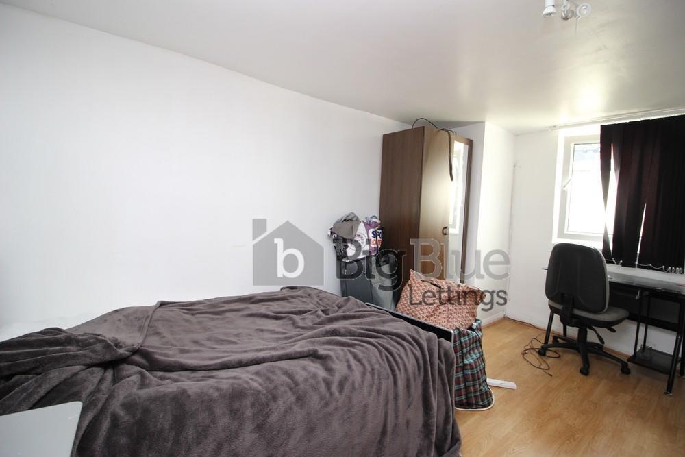 A cozy single bedroom featuring a neatly made b...